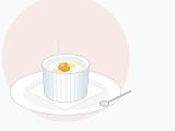 Egg en cocotte with cream in a small white ramekin on a folded napkin, white fully set and a glossy yolk ready to be broken with a spoon
