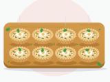 Illustration of eight mini quiches with golden fluted pastry on a wooden board, each topped with a quail egg with a fully set white and yolk, sprinkled with chives and parsley